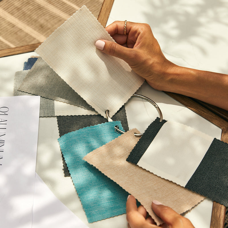 Hands hold a ring of fabric swatches.